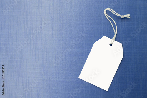 Blank white price tag with space on blue texture background, business concept sale tag or sign