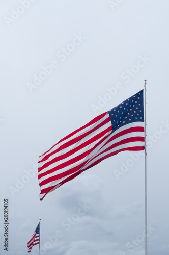 Two Unfurled American Flags Against a Cloudy Sky