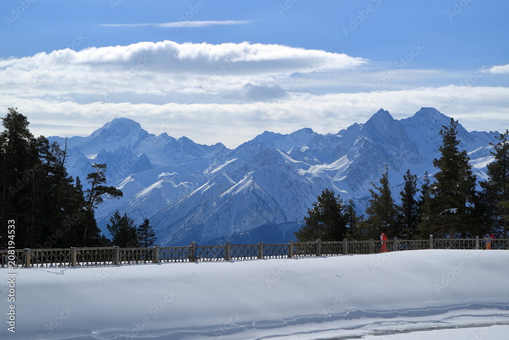 A pedestrian walkway against the background of snowy mountain peaks.