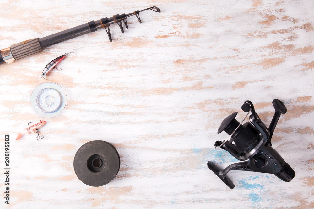 Fishing rod reel on wood background Fishing rod reel on wood background