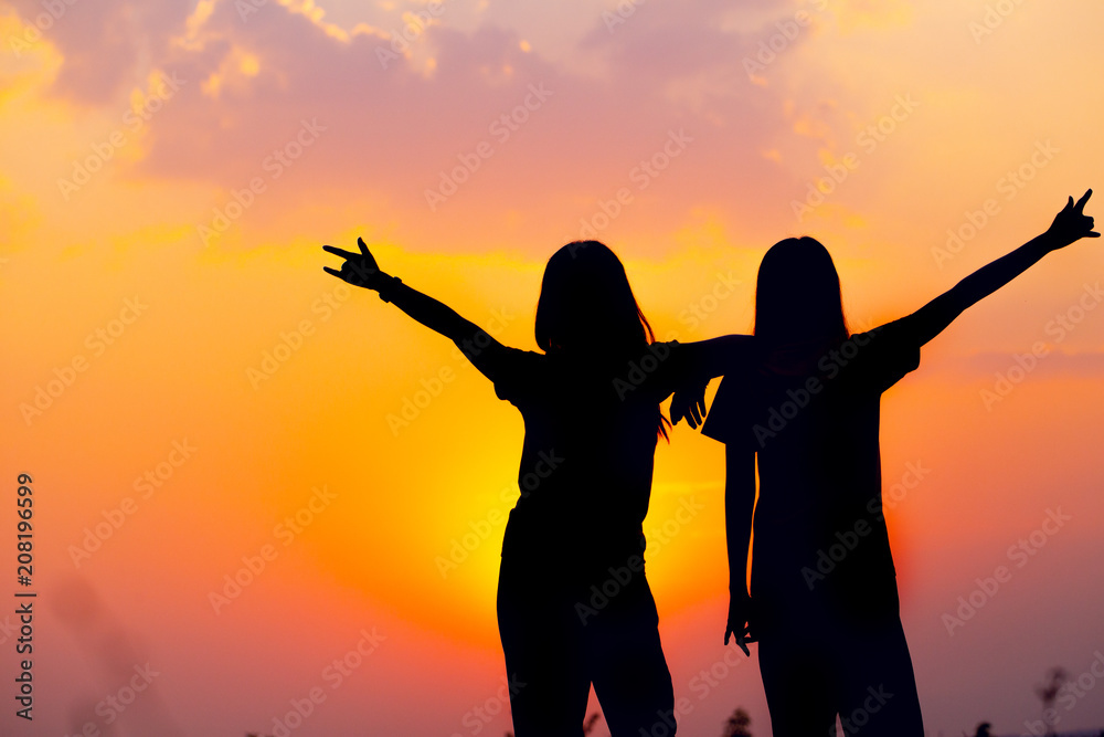 silhouette of two girls friend happy friendship smiling laughing with sunset view