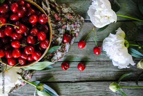 Ripe red cherries and white peonies
