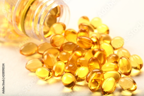 Fish oil capsules dropping from bottle.