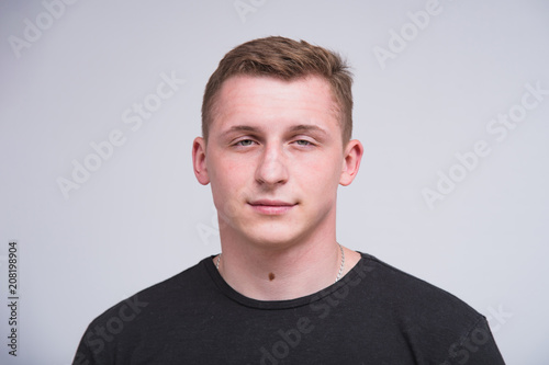 portrait of a cute young guy on a white background in different poses with different emotions.