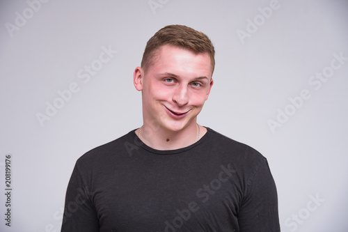 portrait of a cute young guy on a white background in different poses with different emotions.