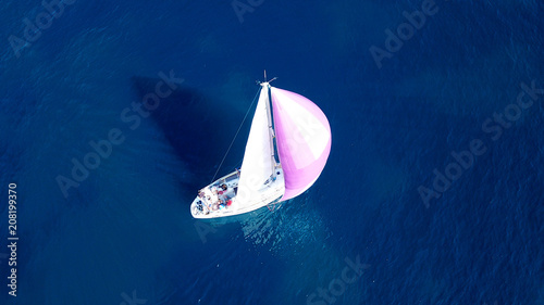 Aerial drone bird's eye view of beautiful purple sail boat cruising in deep blue ocean © aerial-drone