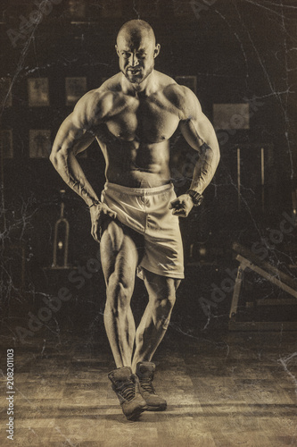 Vintage photos of strong bodybuilder athletic man pumping up muscles workout bodybuilding concept background © ValentinValkov