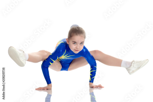 A girl gymnast performs exercises on the floor. photo