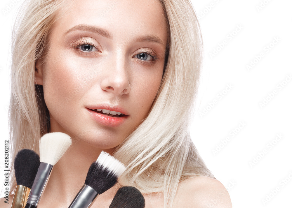 Beautiful young girl with a light natural make-up,brushes for cosmetics and nude manicure. Beauty face. Picture taken in the studio on a white background. Beautiful young girl with a light natural make-up,brushes for cosmetics and nude manicure. Beauty face. Picture taken in the studio on a white background.