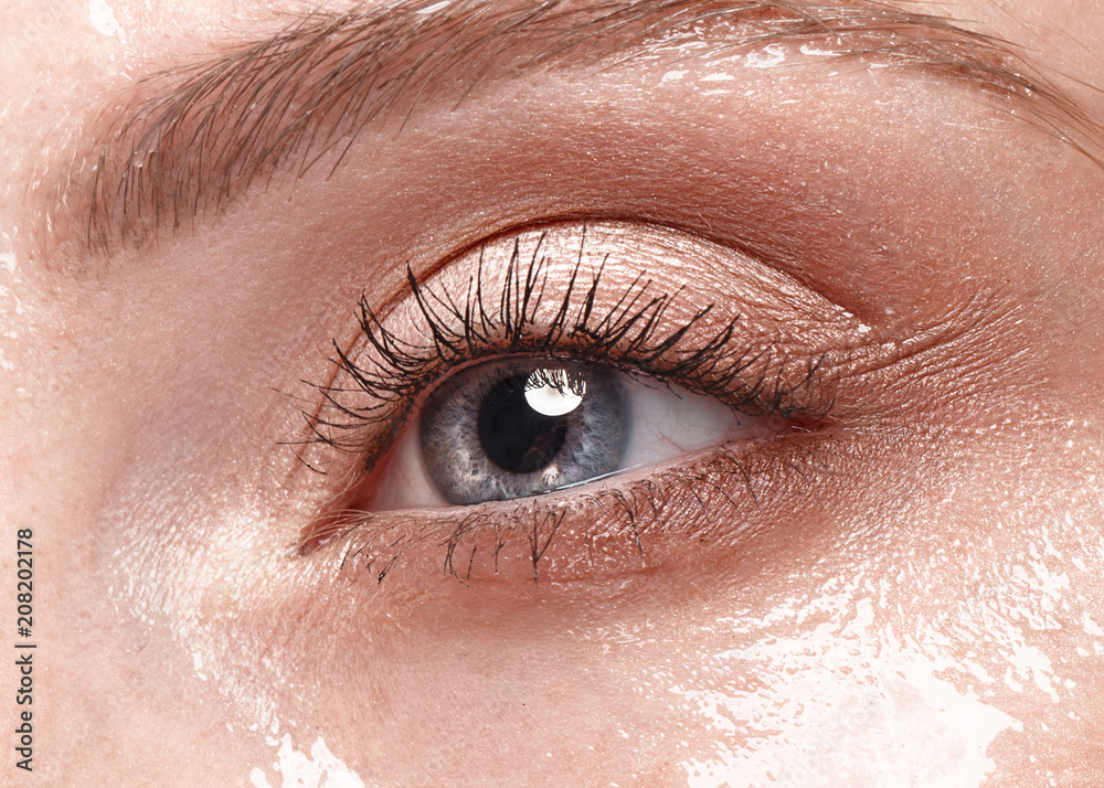 Fototapeta premium Beautiful young girl with a light natural make-up and perfect wet skin. Beauty face. Picture taken in the studio on a white background.