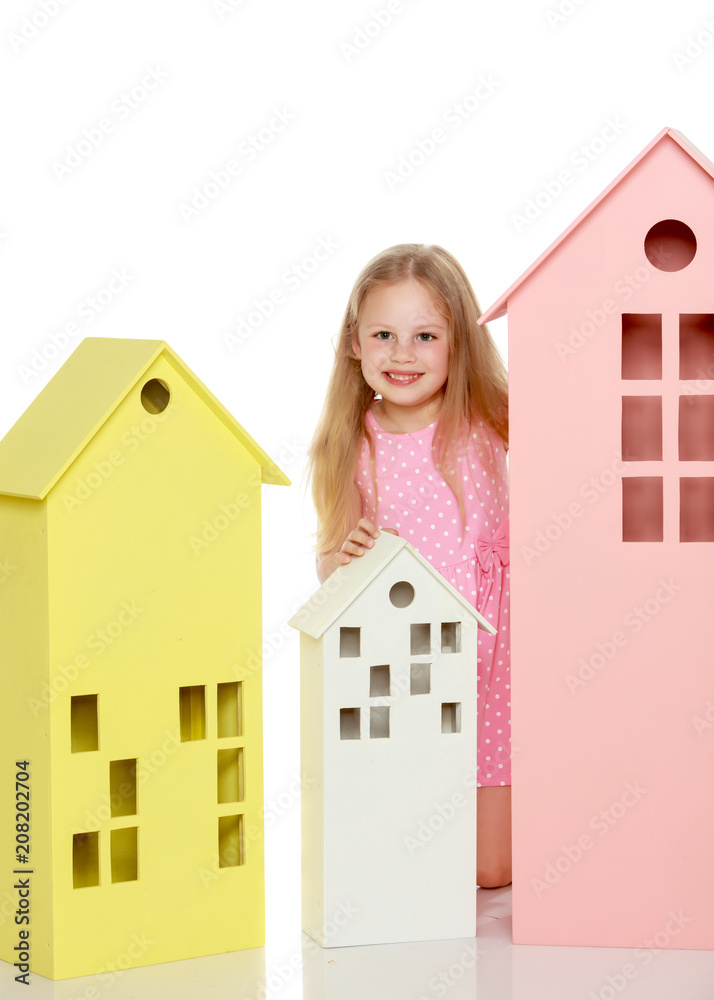 Little girl is playing with wooden houses. Little girl is playing with wooden houses.