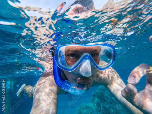 Snorkeling guy underwater doing scuba ok sign