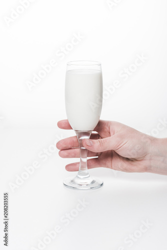 cropped shot of woman holding wineglass of milk isolated on white
