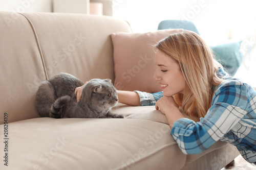 Young woman with her cute pet cat at home