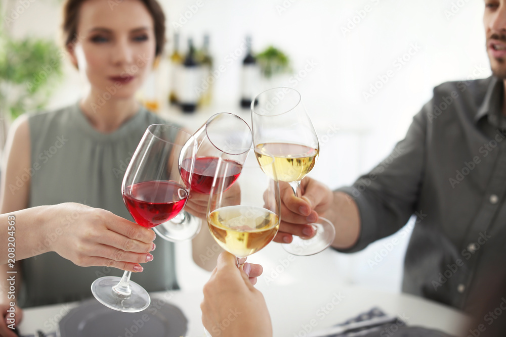Young people with glasses of delicious wine at table