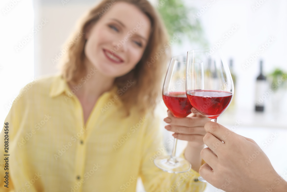 Young couple with glasses of delicious wine indoors Young couple with glasses of delicious wine indoors