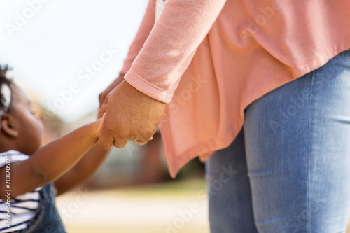 Little girl holding her mothers hand.