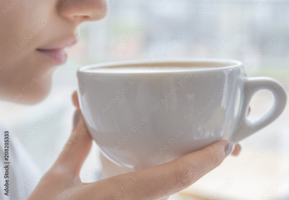 Cafe latte in big white cup in girl hands ready to drink Cafe latte in big white cup in girl hands ready to drink