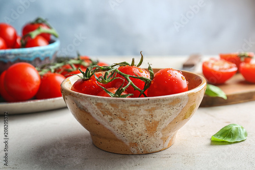 Bowl with fresh ripe red tomatoes on table
