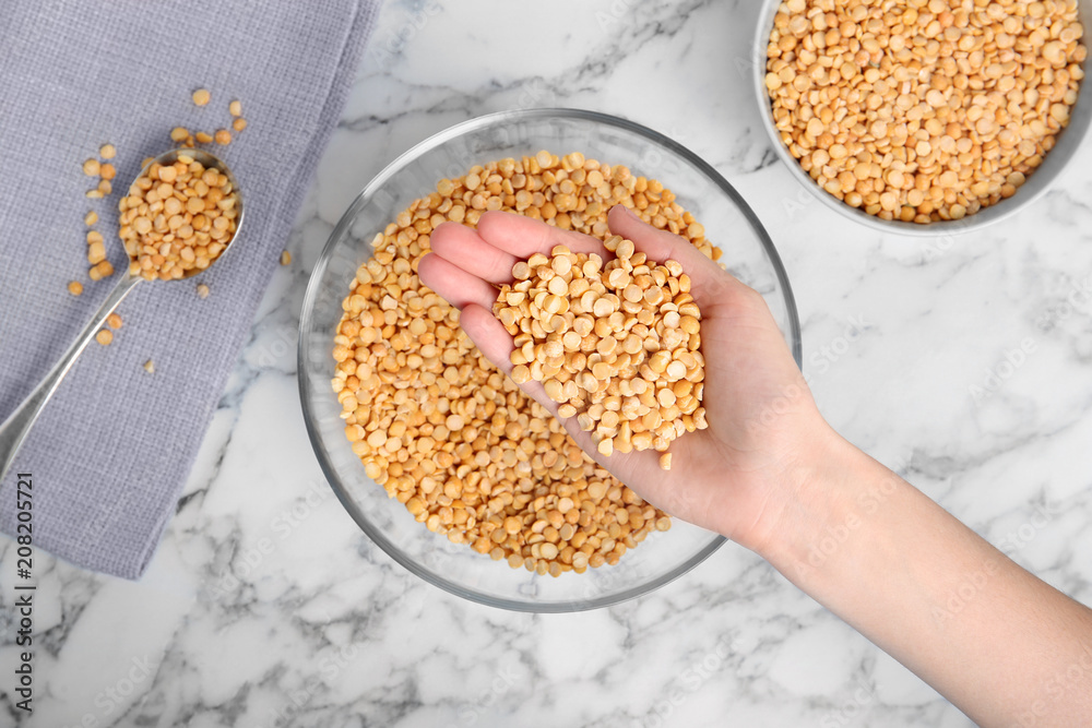 Woman holding dried peas over table, top view Woman holding dried peas over table, top view