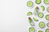 Flat lay composition with cucumber, bottles and cotton pads on white background