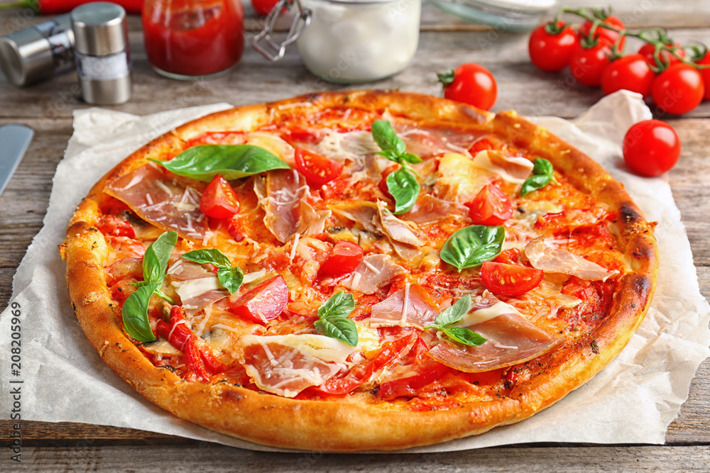 Delicious pizza with tomatoes and meat on table