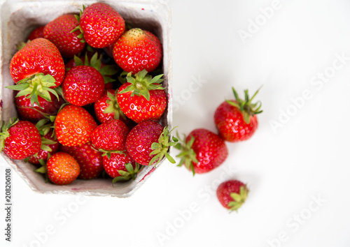 Frische Erdbeeren in der Pappverpackung von oben fotografiert flatlay vor weißem Hintergrund