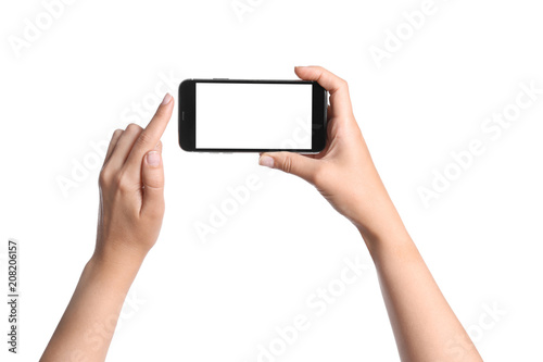 Young woman holding mobile phone with blank screen in hands on white background