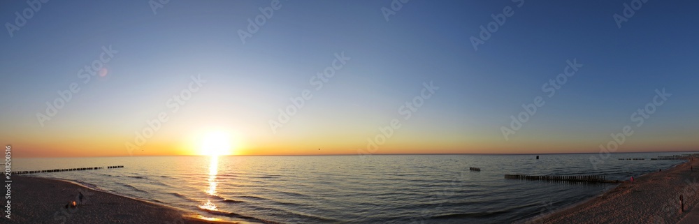 Sand Beach Seaside during Sunset with Clouds and Breakwaters