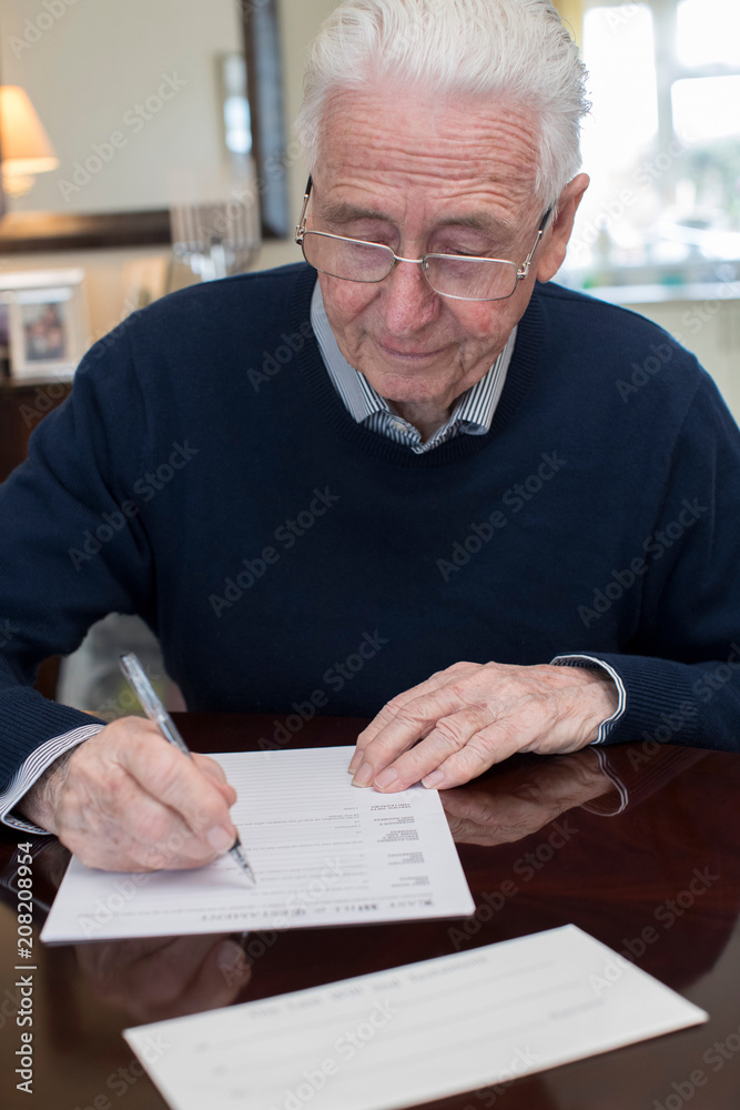 Senior Man Signing Last Will And Testament At Home Senior Man Signing Last Will And Testament At Home