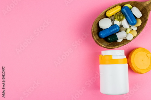 Capsules and tablets on wooden spoon. Medicine pharmaceutical theme. Free space for text
