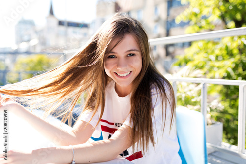 Laughting happy female model with long flying hair and blue eyes smiling at camera and spends weekend outside
