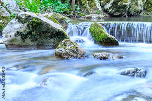Fototapeta Naklejka Na Ścianę i Meble -  Beautiful scene of waterfall with stone cascade and large rocks covered with moss