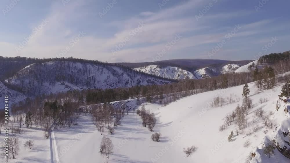Frozen mountain river at winter sunny day in Ural mountains. Belaya river. Agidel - Aerial View Frozen mountain river at winter sunny day in Ural mountains. Belaya river. Agidel - Aerial View