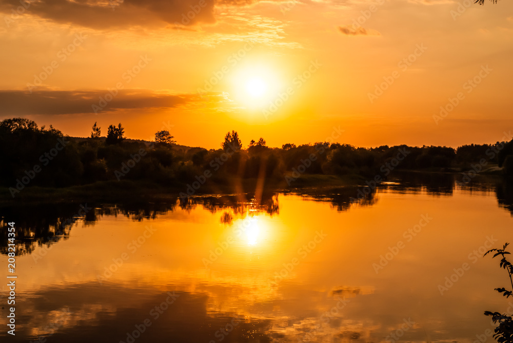 Sunset on the river Berezina with the reflection of the sun in the water