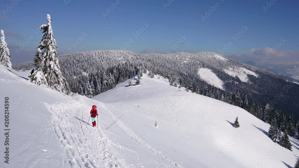 Winter hiking in rocky mountains landscape covered in snow during cold weather on sunny day Winter hiking in rocky mountains landscape covered in snow during cold weather on sunny day
