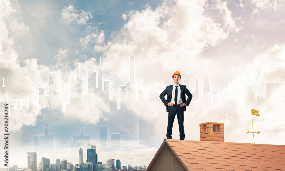 Engineer man standing on roof and looking away. Mixed media Engineer man standing on roof and looking away. Mixed media
