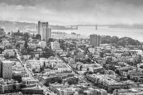 Aerial view of San Francisco skyline. Panorama black and white of the Golden Gate Bridge, Fisherman's Wharf and North Beach from top of Coit Tower on sunny day, California, United States.