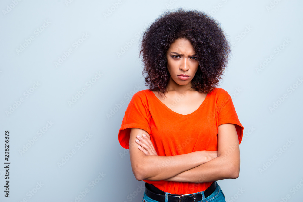 Portrait with copy space empty place of sad offensive woman with modern hairdo holding arms crossed looking at camera isolated on grey background Portrait with copy space empty place of sad offensive woman with modern hairdo holding arms crossed looking at camera isolated on grey background
