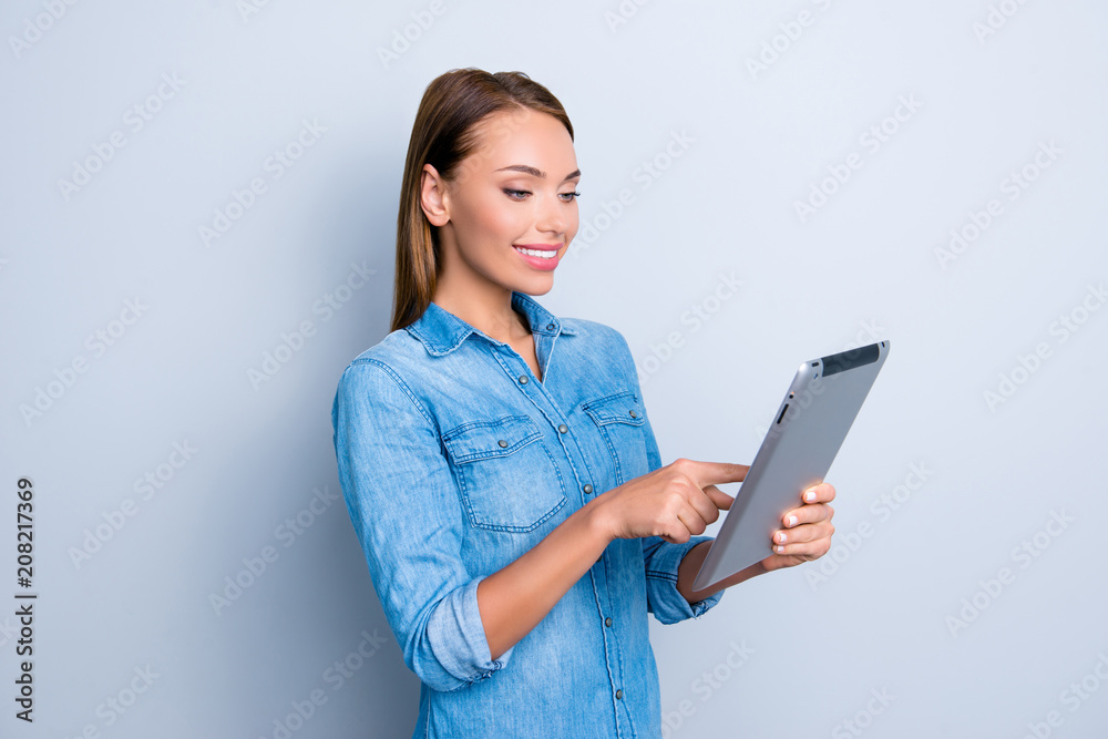 Portrait of modern busy girl having tablet in hands checking email chatting in social networks with friends using wifi internet isolated on grey background Portrait of modern busy girl having tablet in hands checking email chatting in social networks with friends using wifi internet isolated on grey background