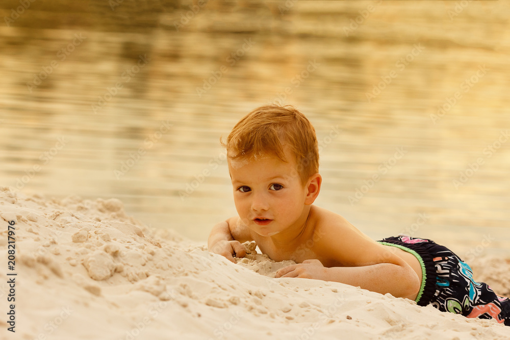 Baby boy playing with sand on beach Baby boy playing with sand on beach