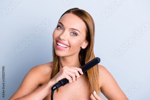 Hand shiny silky smooth curls wavy make prepare design tool temperature ceramic wet bathroom concept. Close up portrait of beautiful cute girl holding hot iron in hand isolated on gray background