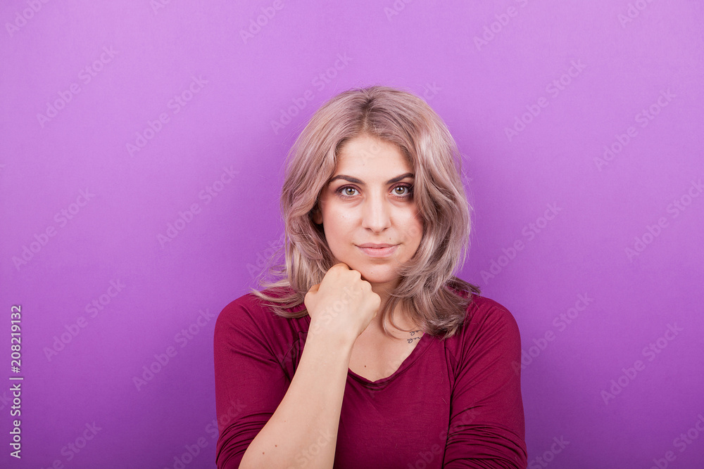 Happy smiling young blonde woman portrait on purple background