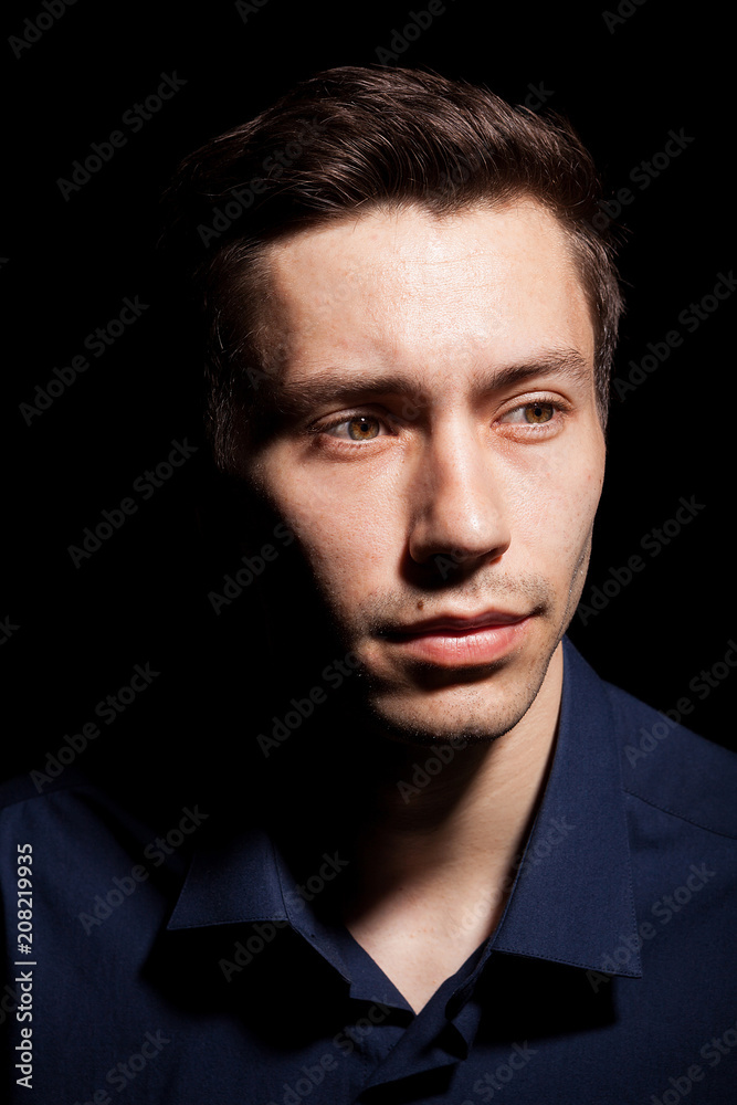 Portrait of young man in his 20s on black background in studio photo