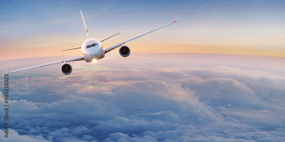 Naklejka premium Komercyjny samolot latający nad chmurami.