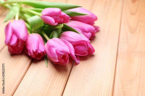 Beautiful fresh tulips on wooden background