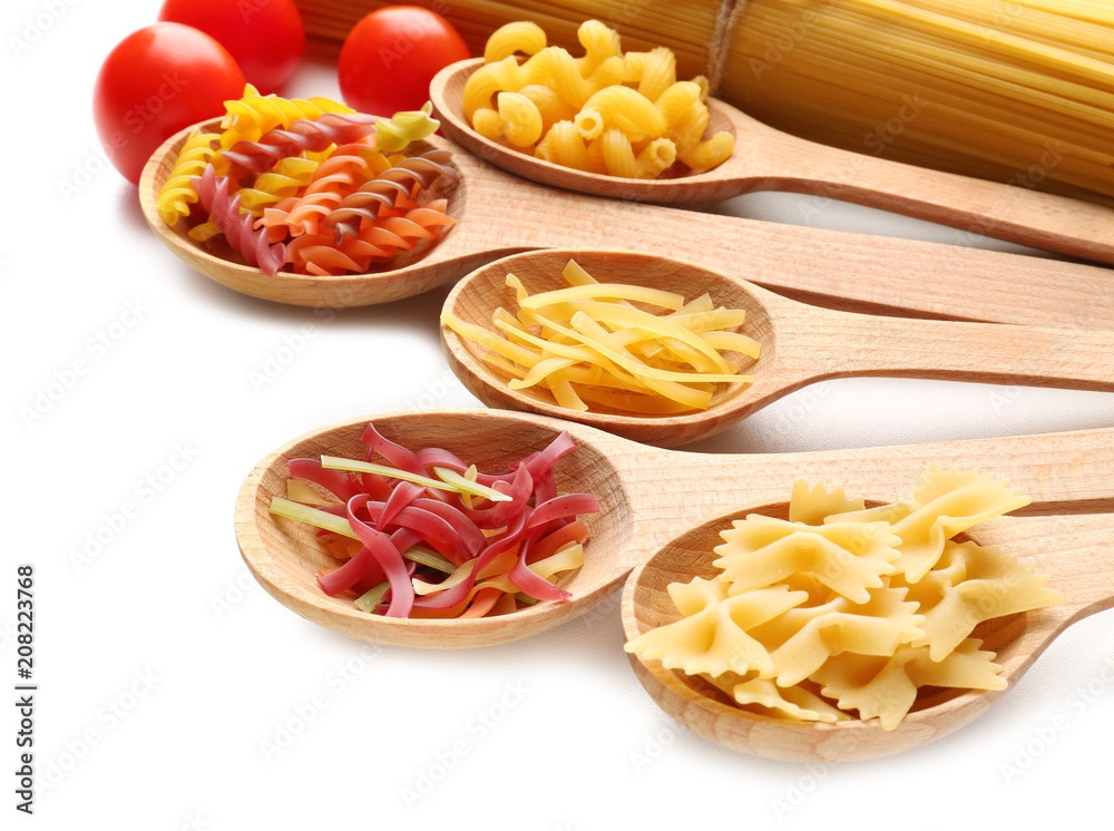 Wooden spoons with uncooked pasta on white background Wooden spoons with uncooked pasta on white background