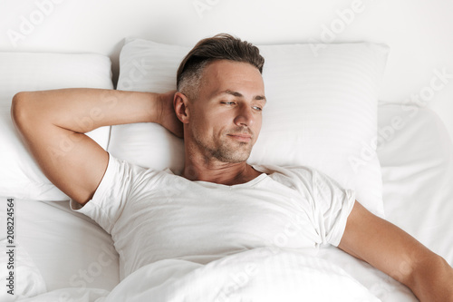 Smiling man relaxing in bed