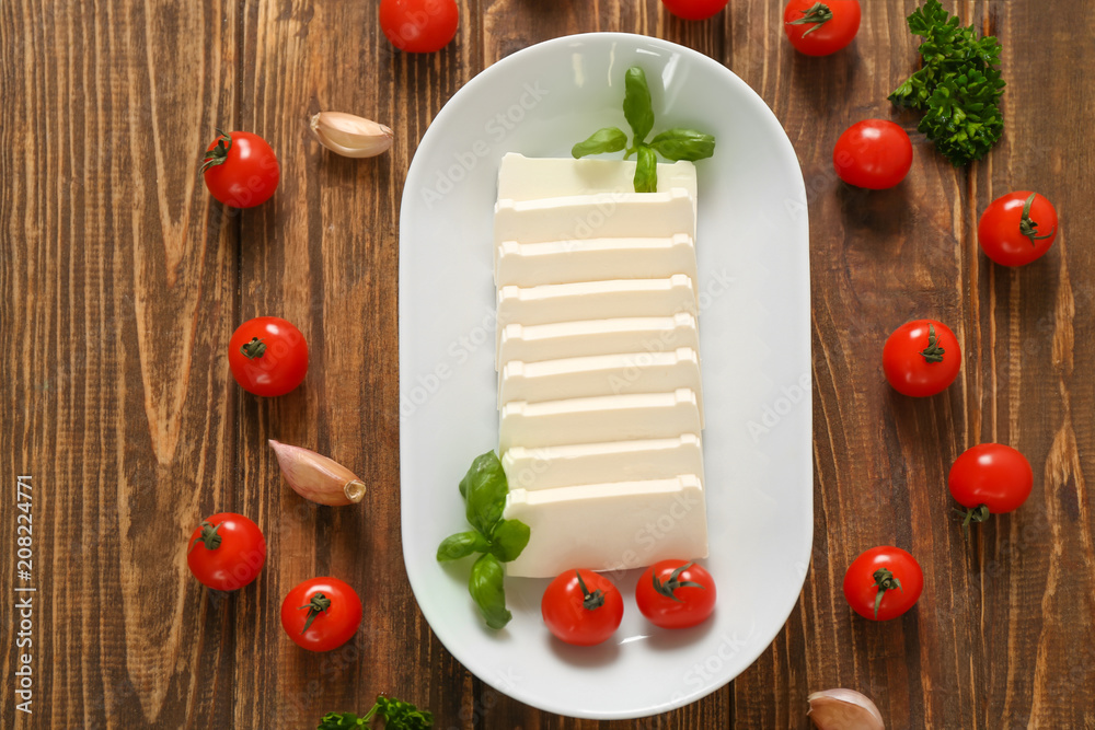 Plate with processed cheese and cherry tomatoes on table Plate with processed cheese and cherry tomatoes on table