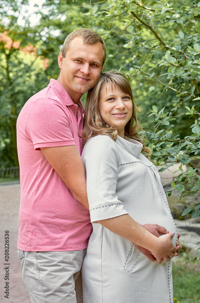 Pregnant woman with husband man in park nature family concept Pregnant woman with husband man in park nature family concept